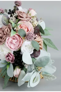 Gros plan détail du bouquet de mariée artificiel avec des roses et des feuilles d'eucalyptus.