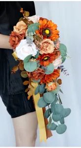 Cascading artificial wedding bouquet with sunflowers roses and eucalyptus for bridal photography.