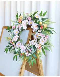 Detailansicht des künstlichen Frühlingsblumenkranzes mit rosa Gänseblümchen für die Wanddeko.