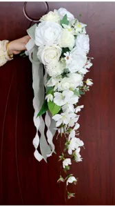 Weißer künstlicher Kaskaden Brautstrauß mit schönen Bändern für die Hochzeitsfotografie.