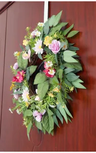 Frühlings künstlicher Blumenkranz Detail mit lebendigen Blumen und natürlicher Rebe für Wanddekoration.