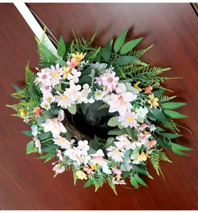 Nahaufnahme des künstlichen Frühlings-Blumenkranzes mit rosa Blüten und grünen Blättern.