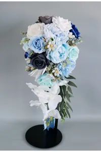 Atemberaubender Kaskaden-Brautstrauss aus blauen und weissen Seidenrosen fuer die Hochzeit.