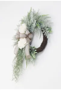 Artificial greenery wreath with white peony and burlap bow for door hanging detail view.