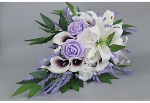 Artificial cascading bridal bouquet with purple roses, white lilies and greenery for wedding.