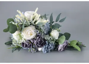 Künstlicher kaskadierender Brautstrauß mit staubblauen weißen Rosen und Eukalyptusblättern.