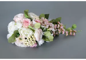 Gros plan d'un bouquet de mariée cascade artificiel avec roses roses blanches et baies pour mariage.