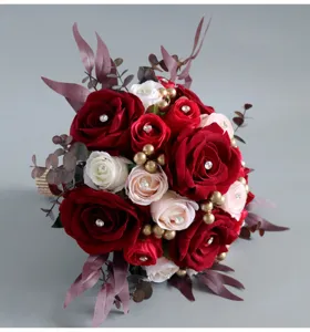 Close-up detail of the artificial bridal wedding rose bouquet with rhinestones and gold beads.