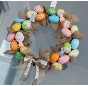 Easter wreath detail shot featuring colorful eggs, burlap bows, and cute wooden bunnies for holiday decor.