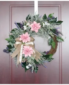 Closeup view of artificial dahlia wreath hanging on the door, detailed floral wedding decor.