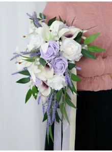 Detailed view of the cascading bridal bouquet with white lilies, purple roses, and ribbons.
