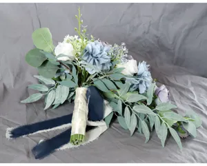 Detailaufnahme eines künstlichen Brautstraußes mit blauen Blumen und Eukalyptusblättern.