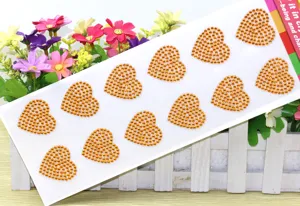 Detailansicht glänzender goldener Strass-Herzsticker auf einer Karte für schöne Bastelprojekte.