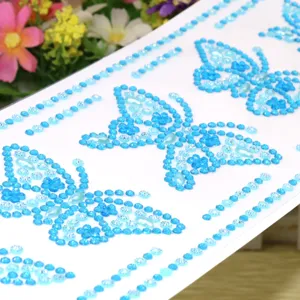 Close-up detail of blue rhinestone butterfly DIY craft stickers, crystal acrylic gems for decor.