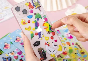 Close-up detail of 3D cartoon puffy stickers featuring cute animals on a clear phone case.