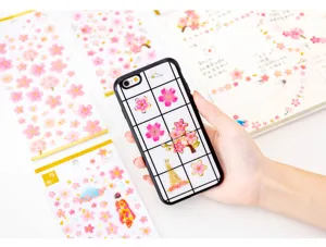 Vue détaillée de mignons autocollants époxy dorés avec des fleurs de cerisier pour art.