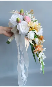 Nahaufnahme des Kaskaden-Brautstraußes mit weißen Rosen, Bändern und künstlichen Blumen.