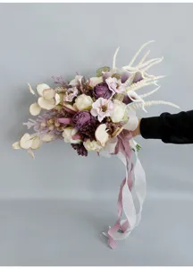 Detail shot of European retro artificial bridal wedding bouquet with burned-edge roses and ribbons.