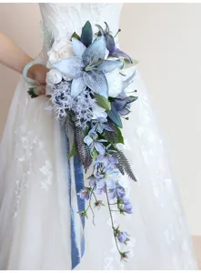 Vista dettagliata del bouquet da sposa a cascata con gigli blu e rose bianche per cerimonia nuziale.