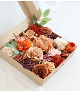 Vista detallada de rosas y peonías artificiales surtidas, ordenadas en una caja de cartón kraft.