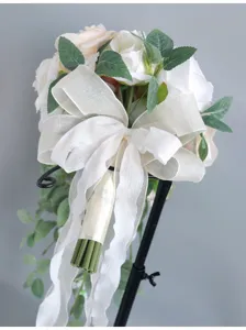 Eleganter künstlicher Hochzeits-Kaskaden-Brautstrauß mit weißen Rosen und großer Schleife.