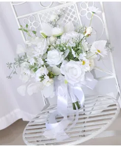 Nahaufnahme des weißen Brautstraußes mit Rosen und Margeriten als Hochzeits-Requisite.