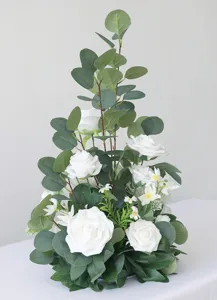 Detailaufnahme von künstlichen weißen Rosen und Eukalyptus für die Tischdekoration.