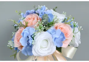 Close-up detail shot of artificial rose and blue hydrangea wedding bouquet with ribbon.