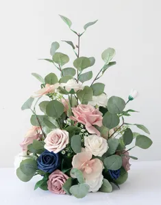 Detailansicht der künstlichen Hochzeitsblumenkomposition mit bunten Rosen und Eukalyptusblättern.