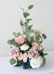 Nahaufnahme des künstlichen Blumenarrangements mit rosa Rosen, Orchideen und Eukalyptus.