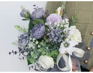 Detailansicht des künstlichen Brautstraußes mit verschiedenen Seidenblumen und Grün.