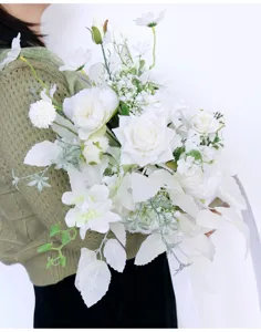 Nahaufnahme des eleganten weißen künstlichen Brautstraußes mit üppigem Grün für Hochzeiten.