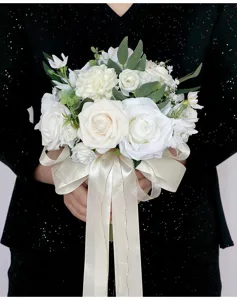 Detailaufnahme des künstlichen weißen Rosenbrautstraußes mit feinen Blättern und eleganter Schleife.