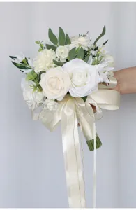 Nahaufnahme des künstlichen weißen Rosen Brautstraußes mit edler elfenbeinfarbener Schleife.