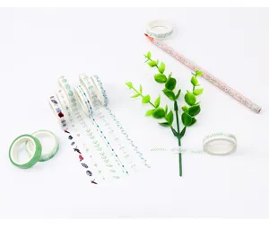 Details of green floral washi tape rolls and unwound decorative strips for DIY crafts.