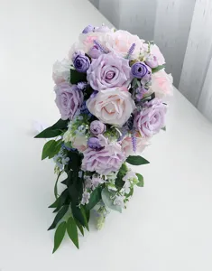 Dettaglio del bouquet artificiale a cascata con rose rosa e viola e foglie verdi.