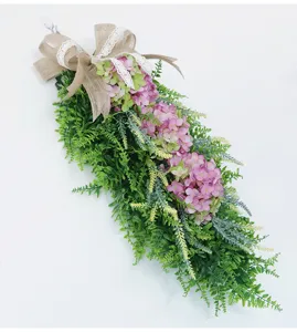 Detailed view of the artificial pink hydrangea hanging flower swag with a rustic burlap bow.