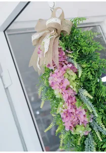 Artificial hanging hydrangea flower wreath with burlap bow, perfect for front door decor.