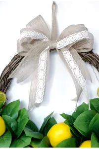 Primo piano della ghirlanda di foglie di limone artificiale con fiocco in juta per decoro.