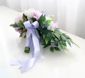 Dettaglio in primo piano del bouquet da sposa artificiale a cascata con rose rosa.