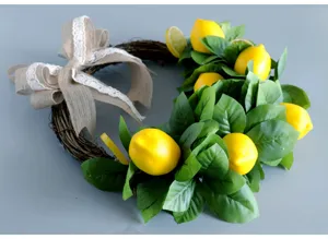 Ghirlanda di limoni artificiali con fiocco in juta foglie verdi per decorazione murale.
