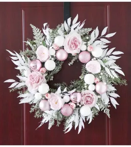 Pink Christmas wreath with artificial roses and baubles for home door and wedding wall decor.