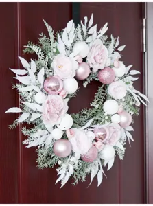 Pink Christmas wreath with delicate peonies and baubles for elegant holiday home decor details.
