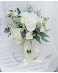 Nahaufnahme des künstlichen Hochzeitsblumenstraußes mit weißen Rosen und Eukalyptusblättern.