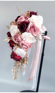 Kaskadierender künstlicher Rosenbrautstrauß mit goldenen Blättern für Hochzeitsfotografie.
