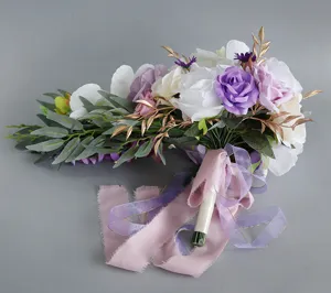Dettaglio del bouquet da sposa a cascata artificiale con rose viola e nastri per decorazioni.