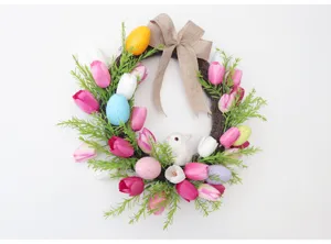 Osterkranz Detailansicht mit bunten Ostereiern, rosa Tulpen und einem süßen weißen Hasen.