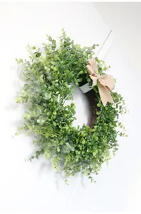 Corona di eucalipto verde artificiale con fiocco in iuta per decorazione murale e porta.