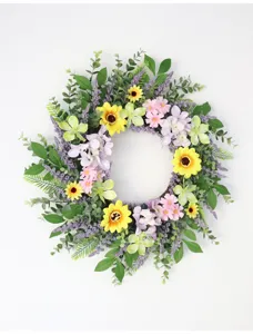 Detail van kunstmatige zonnebloem en madeliefje krans, perfect voor muur- en deurdecoratie.