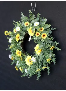 Gedetailleerd overzicht van kunstmatige eucalyptuskrans met zonnebloemen en margrietjes voor lente.